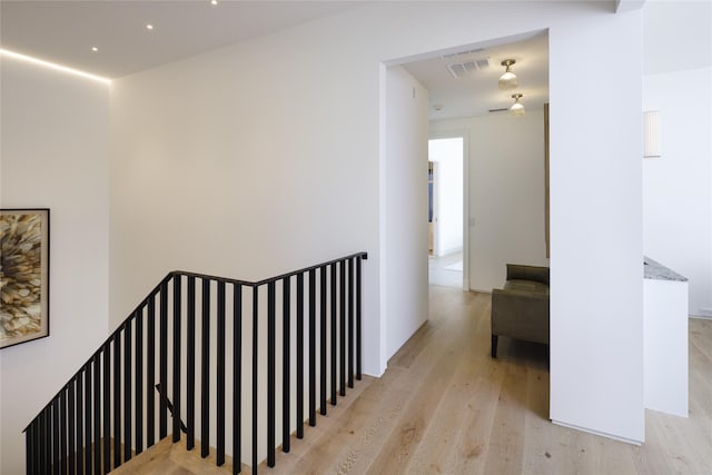 hallway featuring light wood-style floors and visible vents