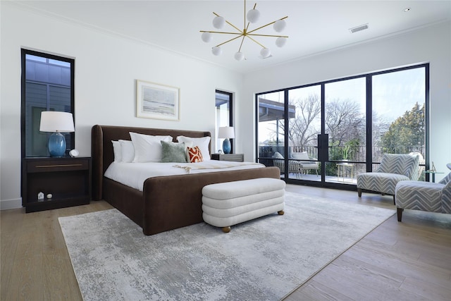 bedroom featuring ornamental molding, wood finished floors, visible vents, and access to exterior