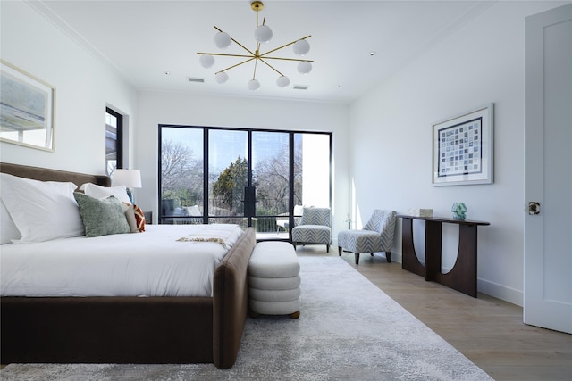 bedroom featuring baseboards, light wood-type flooring, a notable chandelier, and crown molding