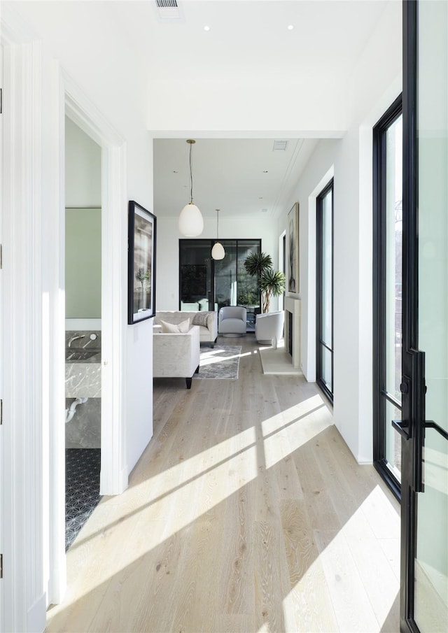 hall with french doors and light wood-style floors