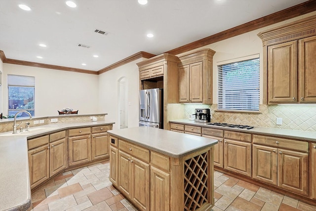 kitchen with light countertops, visible vents, appliances with stainless steel finishes, a kitchen island, and a sink