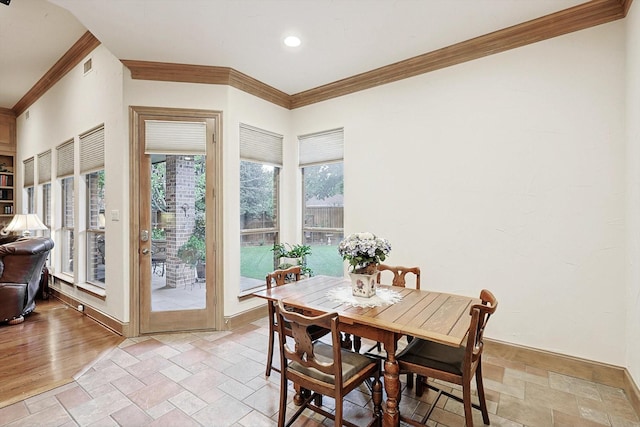 dining area with ornamental molding, stone tile flooring, visible vents, and baseboards