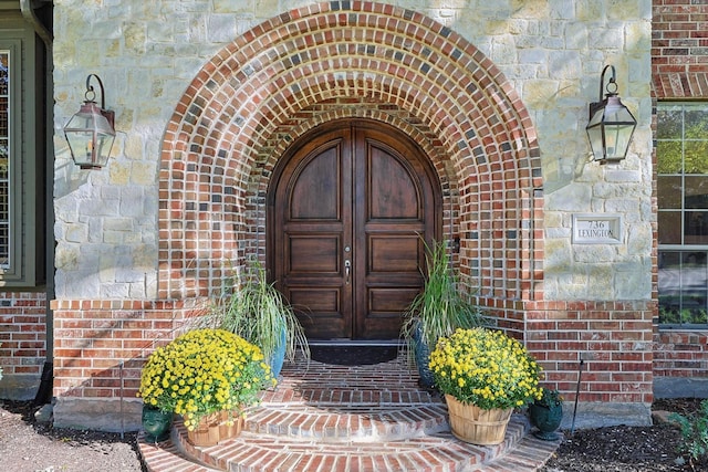 entrance to property with stone siding and brick siding