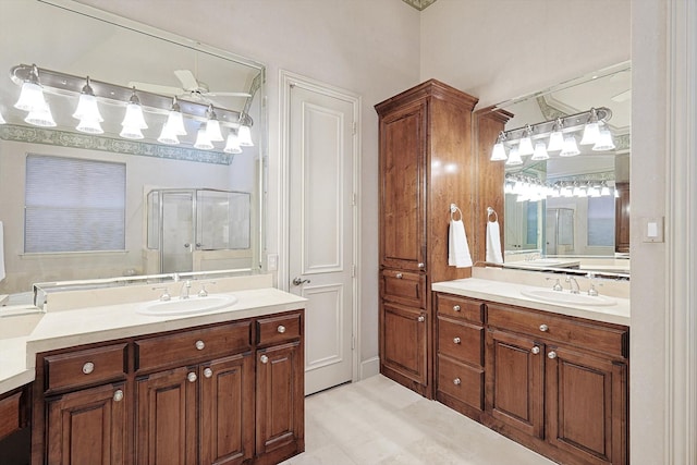 full bath featuring a stall shower, two vanities, and a sink