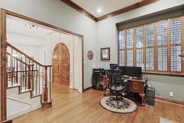 office with arched walkways, crown molding, baseboards, light wood-type flooring, and an inviting chandelier