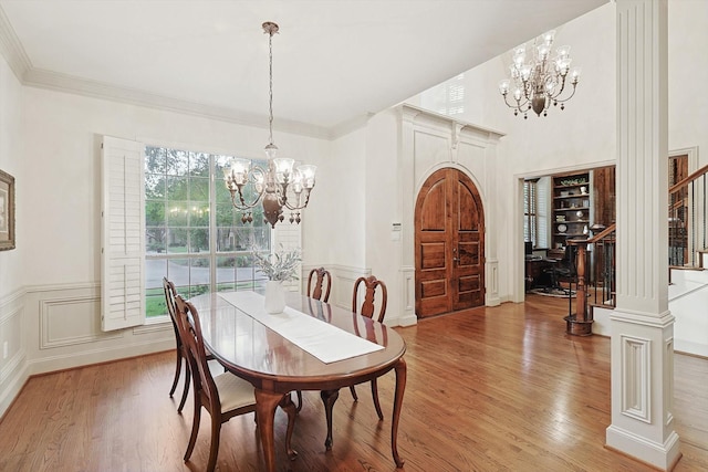 dining space featuring an inviting chandelier, stairs, and wood finished floors