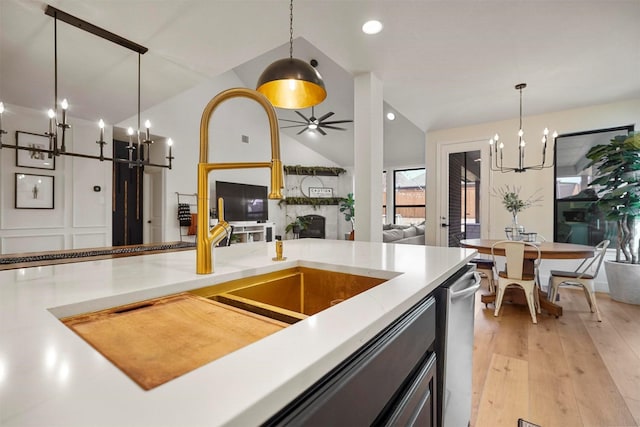 kitchen with vaulted ceiling, a large fireplace, light wood-style flooring, and pendant lighting