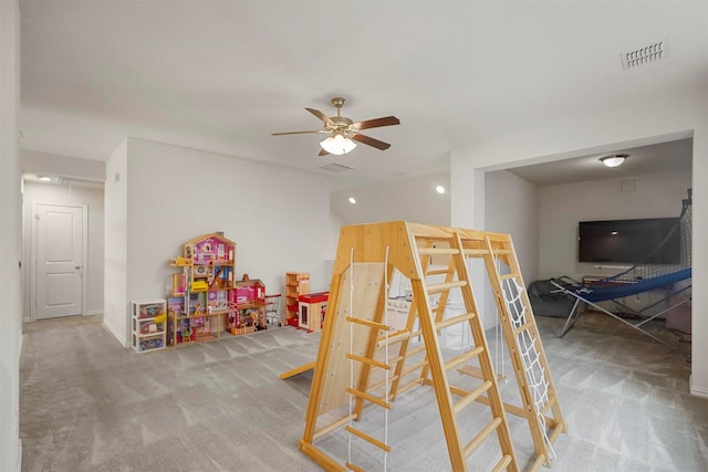 recreation room with ceiling fan, carpet floors, and visible vents