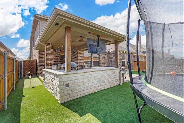 exterior space with a ceiling fan, a fenced backyard, and a grill