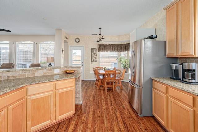 kitchen featuring light stone counters, dark wood-style flooring, light brown cabinets, and a wealth of natural light