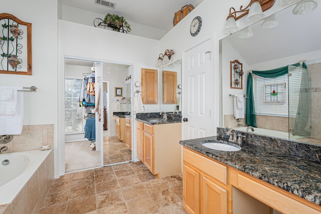 full bath featuring a wealth of natural light, a garden tub, and a sink