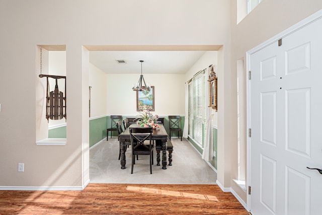 dining area with visible vents, a chandelier, a wealth of natural light, and wood finished floors