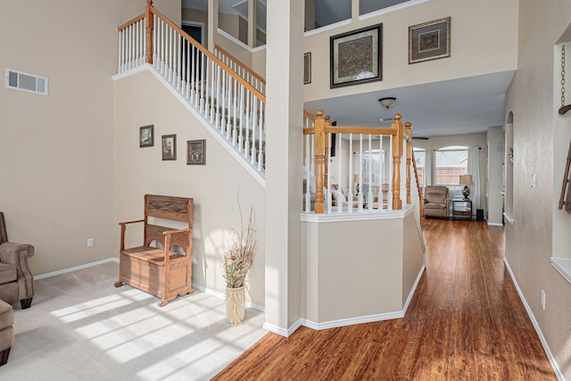 interior space with stairs, a high ceiling, and visible vents