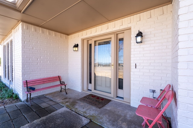 doorway to property featuring brick siding