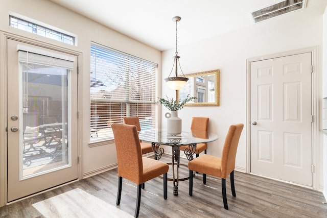 dining space with visible vents, plenty of natural light, and wood finished floors