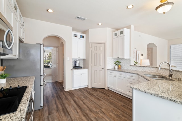 kitchen featuring a sink, visible vents, white cabinetry, stainless steel microwave, and dark wood finished floors