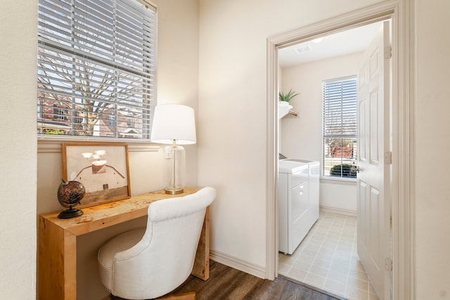 office featuring baseboards, visible vents, wood finished floors, and washing machine and clothes dryer