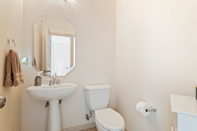 bathroom featuring toilet and baseboards