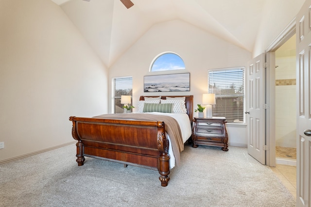 carpeted bedroom with a ceiling fan, vaulted ceiling, and ensuite bath