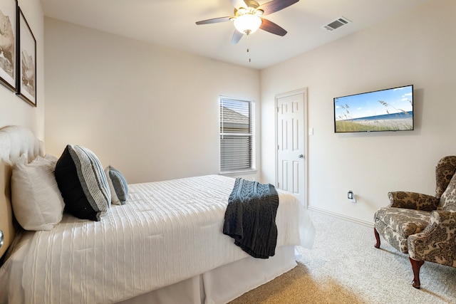 carpeted bedroom featuring a ceiling fan, visible vents, and baseboards