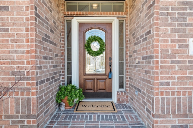 view of exterior entry featuring brick siding