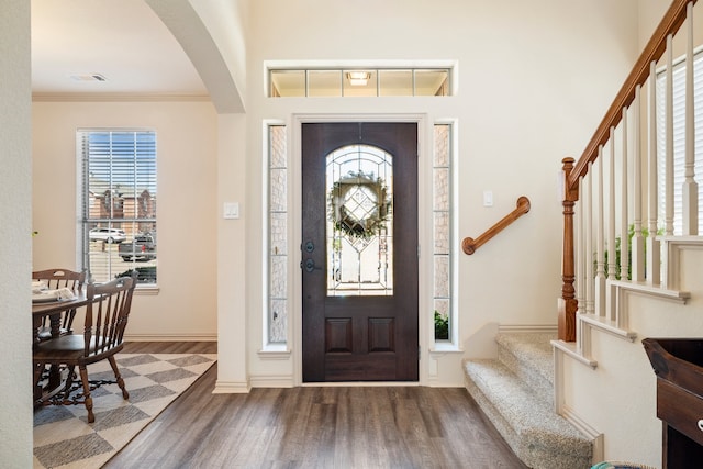 foyer with ornamental molding, a healthy amount of sunlight, visible vents, and wood finished floors