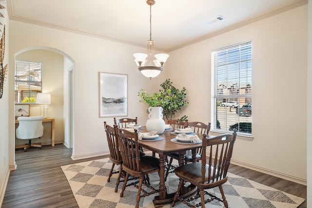 dining room with arched walkways, crown molding, a notable chandelier, visible vents, and baseboards