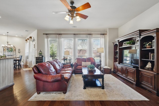 living area with dark wood-style floors, visible vents, and ceiling fan with notable chandelier