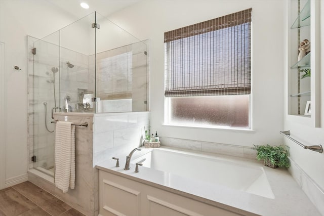 full bath featuring a garden tub, a shower stall, and wood finished floors