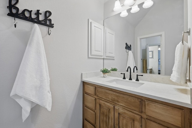 bathroom with lofted ceiling and vanity