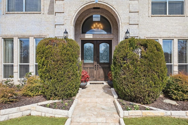 entrance to property featuring brick siding and french doors