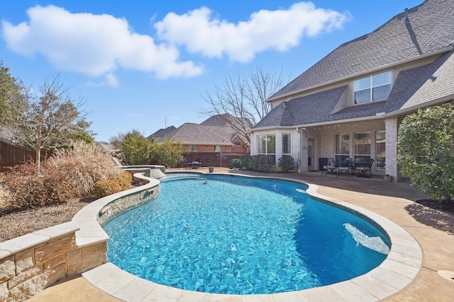 view of pool with a fenced backyard, a pool with connected hot tub, and a patio