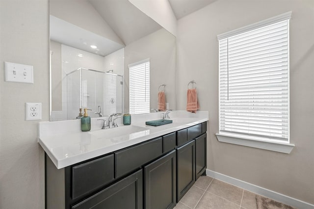 bathroom featuring tile patterned flooring, a sink, a shower stall, and baseboards