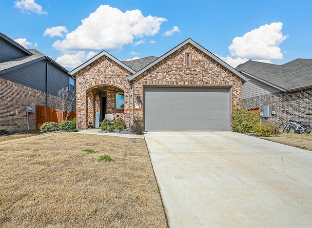 view of front facade with an attached garage, brick siding, fence, concrete driveway, and a front lawn