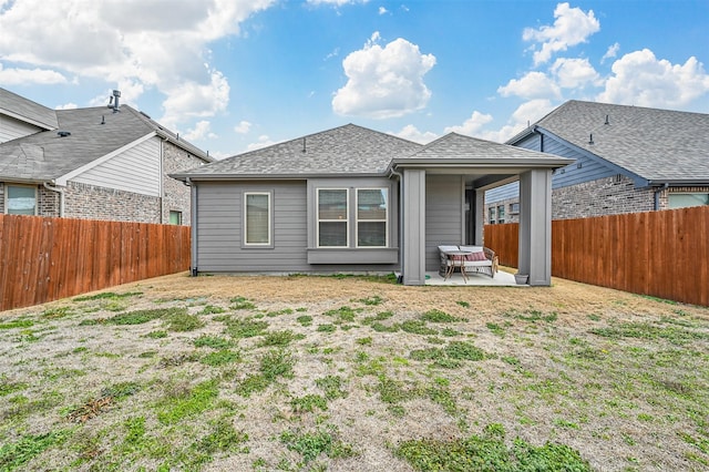 back of house featuring a fenced backyard, a patio, and roof with shingles