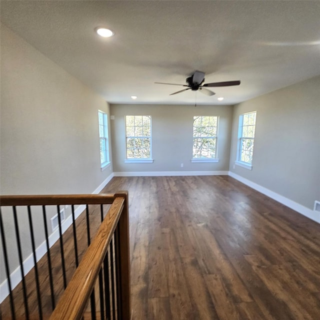 spare room with plenty of natural light, baseboards, dark wood finished floors, and recessed lighting