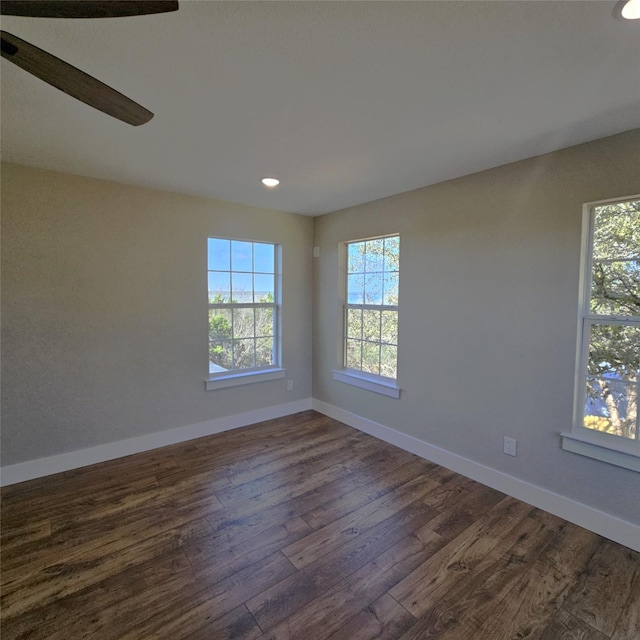 empty room featuring baseboards and dark wood-type flooring