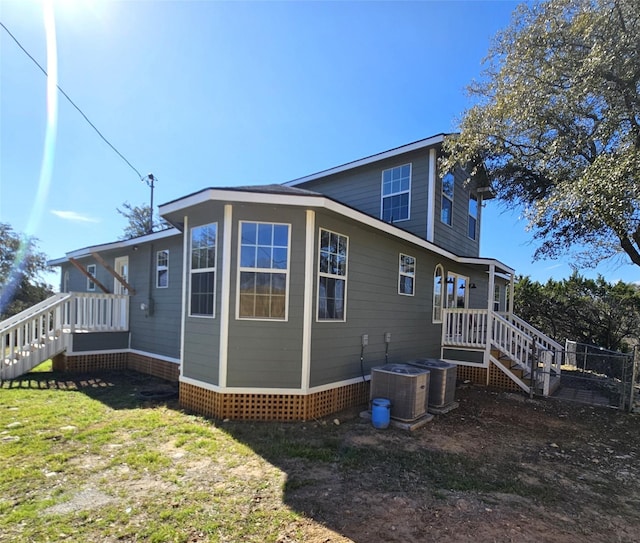 view of side of home with a lawn and central AC unit