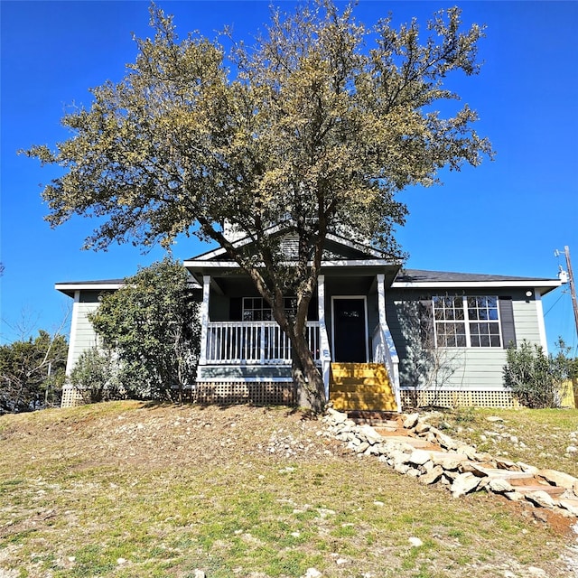 view of front of property with covered porch, a front lawn, and entry steps