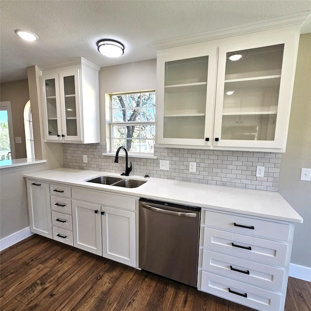 kitchen featuring dark wood-type flooring, a sink, white cabinetry, dishwasher, and glass insert cabinets