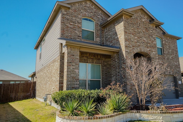 exterior space featuring fence and brick siding