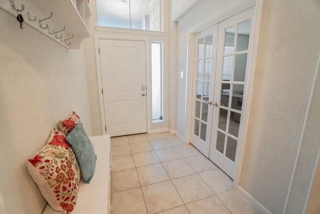 entrance foyer featuring french doors, baseboards, and light tile patterned floors