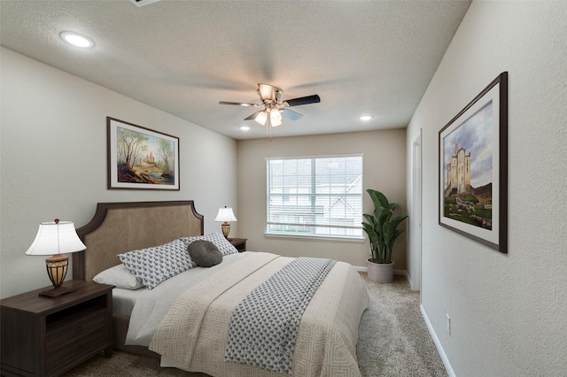 bedroom with a ceiling fan, carpet, baseboards, and a textured ceiling