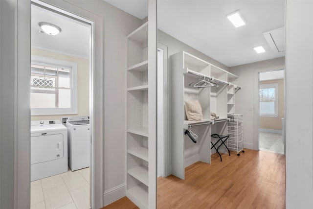 spacious closet featuring light wood finished floors, attic access, and washer and clothes dryer