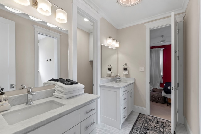 full bathroom featuring ornamental molding, two vanities, a sink, and baseboards