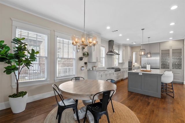 dining room featuring a healthy amount of sunlight, visible vents, and dark wood-style flooring