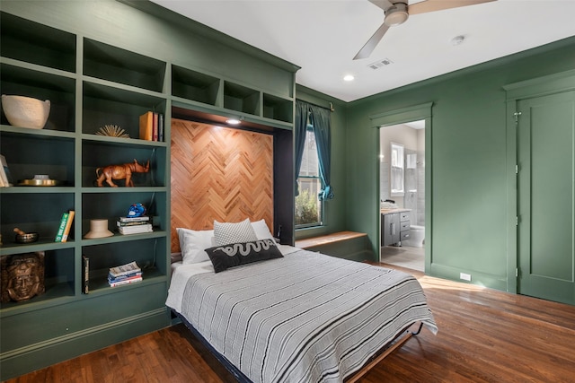 bedroom with dark wood-style floors, visible vents, and connected bathroom