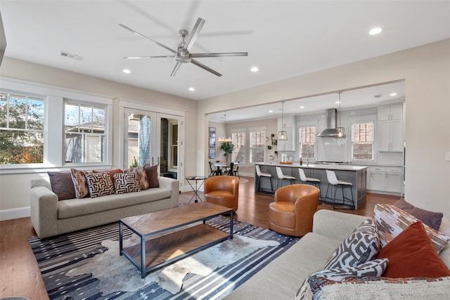 living area with recessed lighting, wood finished floors, a ceiling fan, and baseboards