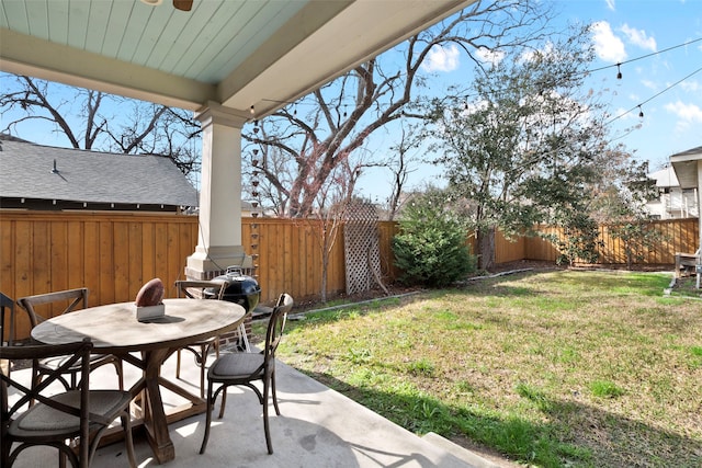 view of yard featuring a patio, outdoor dining space, and a fenced backyard