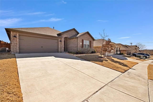 ranch-style house featuring central AC unit, a garage, brick siding, concrete driveway, and roof with shingles